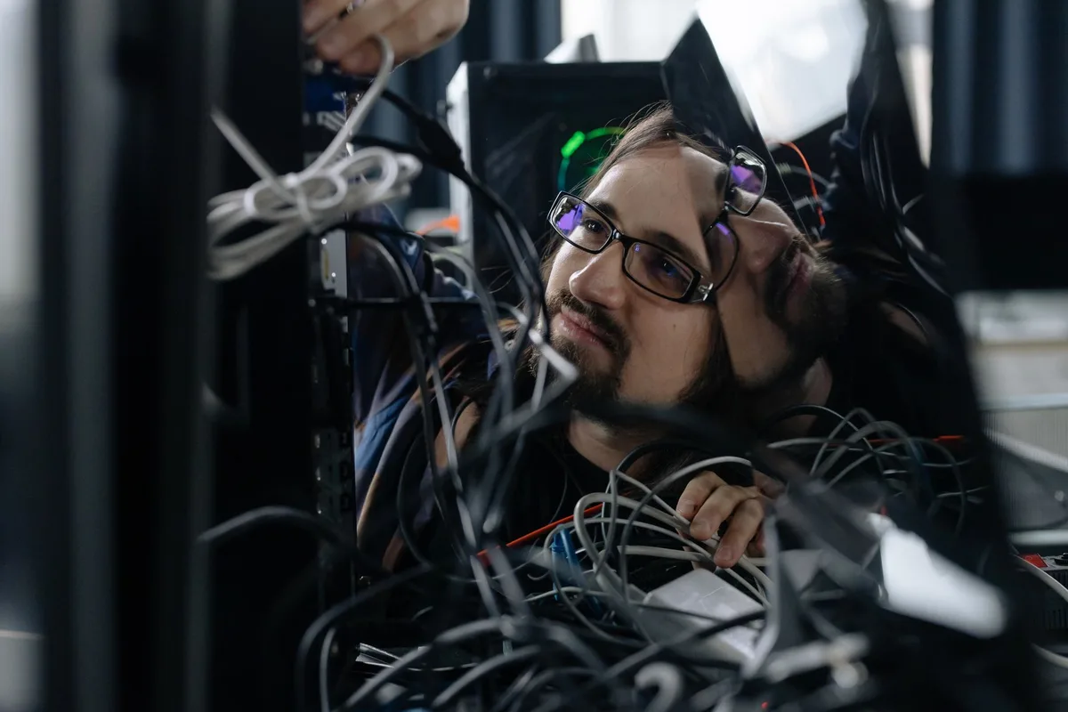 Technicien informatique travaillant sur un ordinateur avec outils de réseau et cybersécurité
