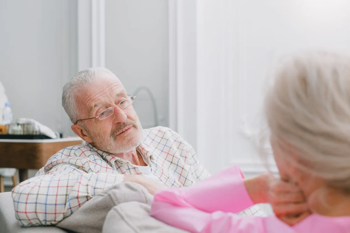 Un senior et une jeune personne en conversation dans un salon