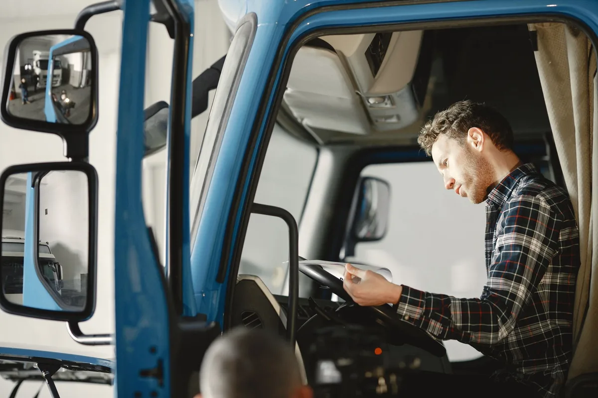 Conducteur effectuant une vérification préalable d'un poids lourd