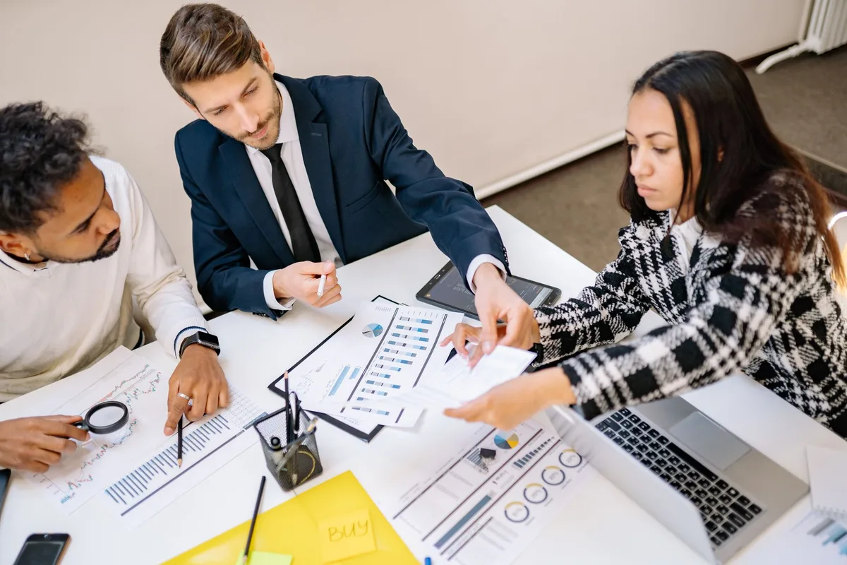 Équipe réunie autour d'une table analysant des données et discutant de stratégie numérique