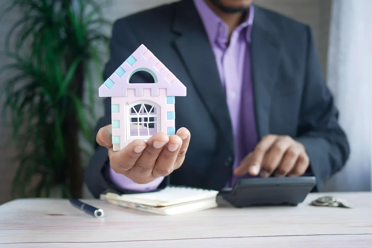 Artisan prenant des mesures dans un logement pour estimer des travaux