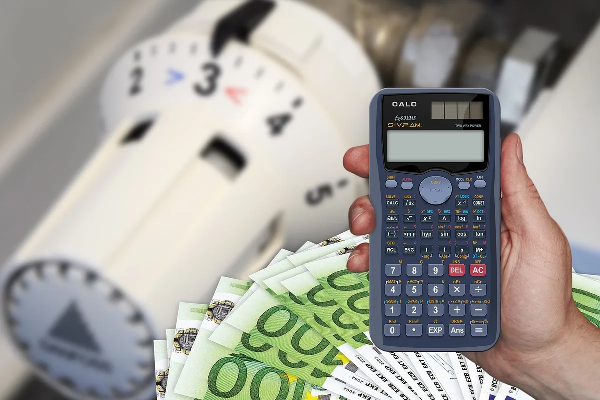 Personne tenant un cahier de budget avec des reçus et des notes de dépenses