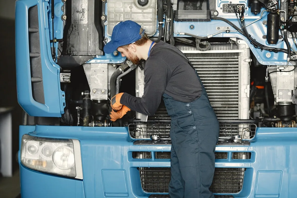Technicien complétant une checklist de maintenance devant un camion