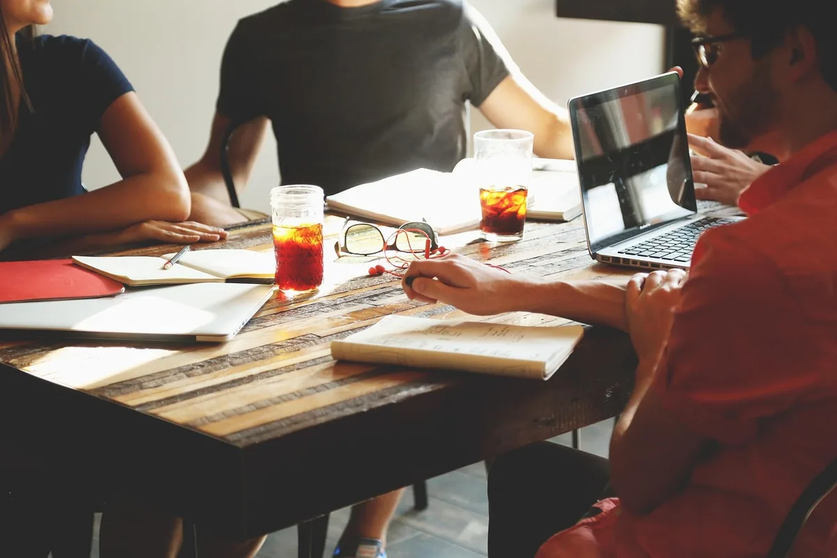 Réunion d'équipe en journée autour d'une table pendant une transformation