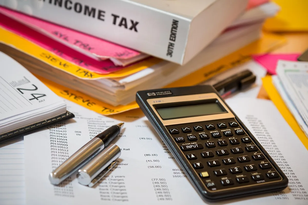 Main pointant le TAEG sur une proposition de financement posée sur un bureau