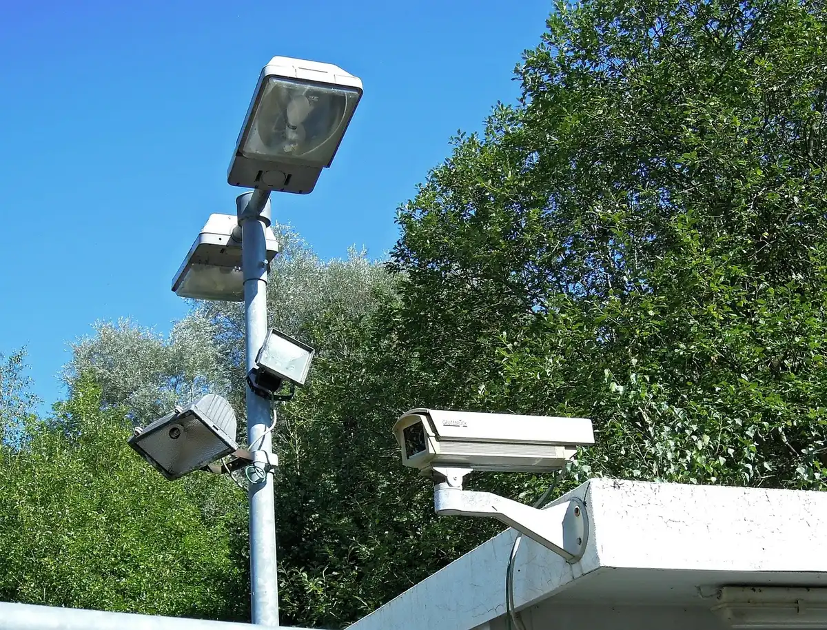Salle de centre de télésurveillance avec écrans anonymisés montrant flux vidéo