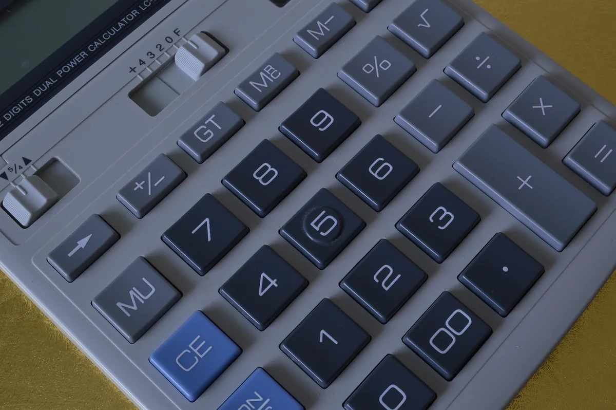 Table avec documents de budget et calculatrice pour calculer le taux d'endettement