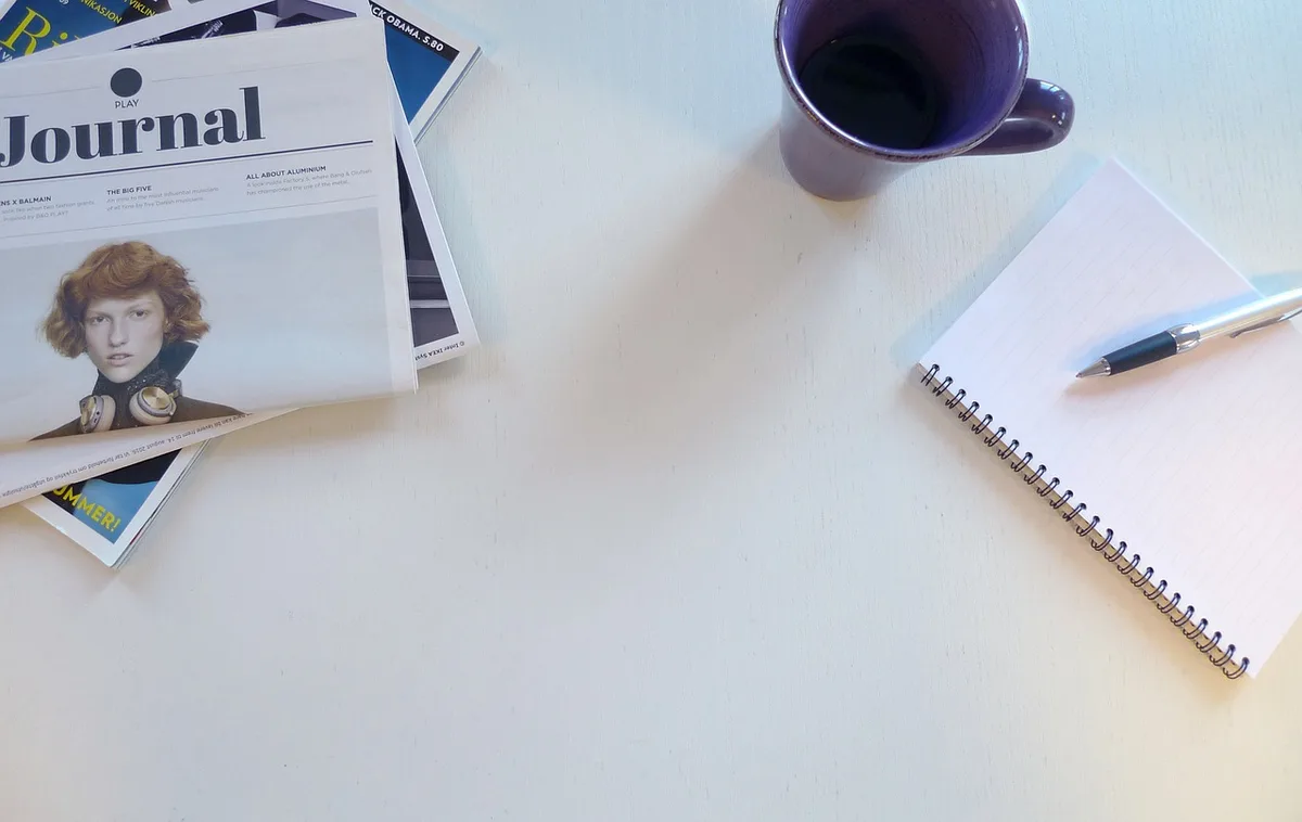 Personne prenant des notes dans un carnet pour préparer un premier post
