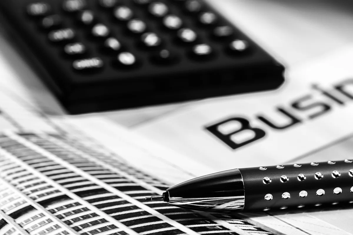 Documents de remboursement et calculatrice posés sur un bureau lumineux