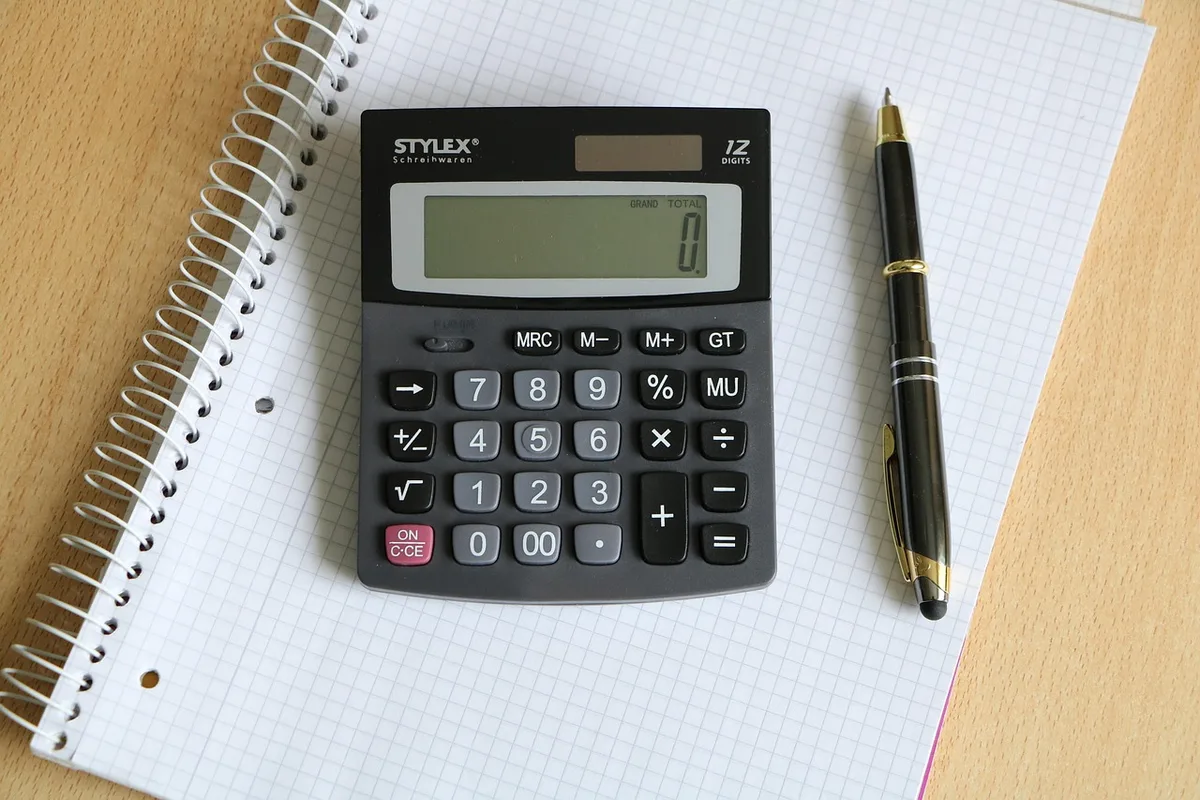 Personne consulte une simulation de prêt sur ordinateur avec une calculatrice