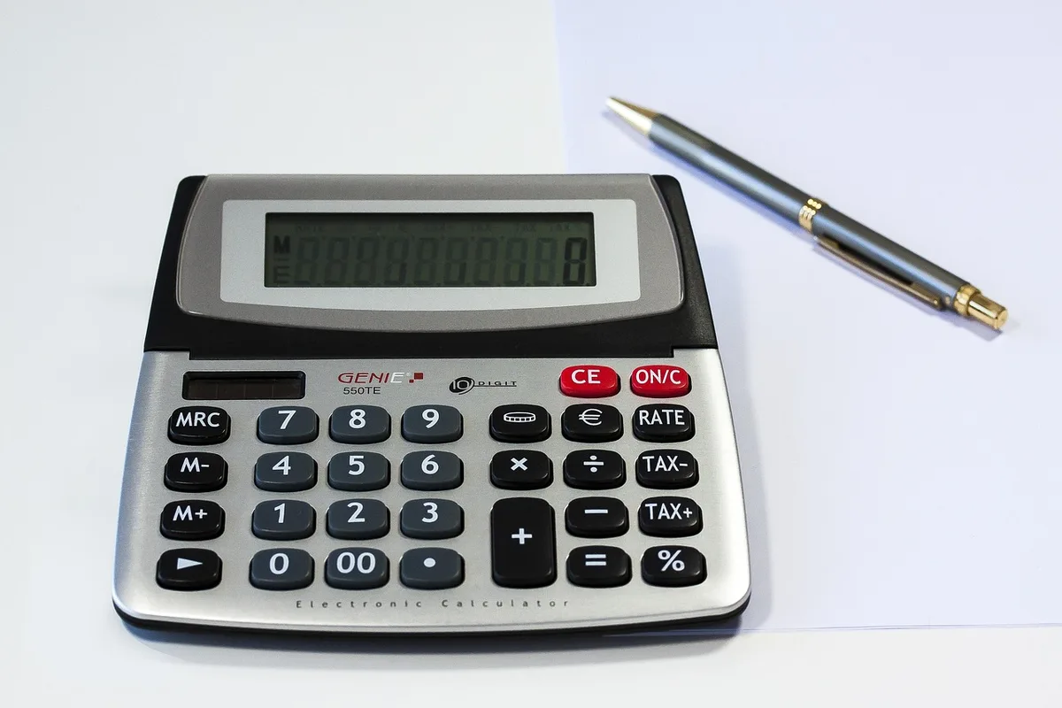 Calculatrice et tableau de rentabilité locative sur un bureau en plein jour