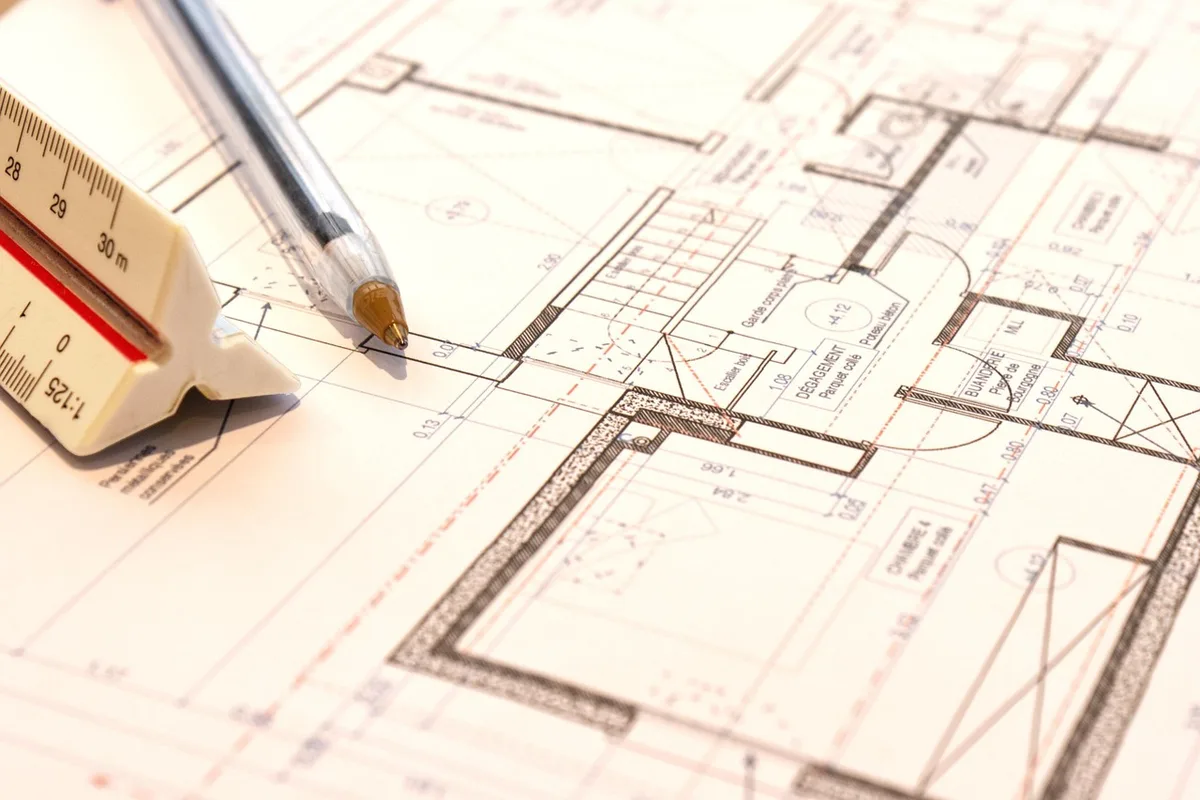 Plans de logement et tablette sur une table, illustrant une annonce "à partir de"