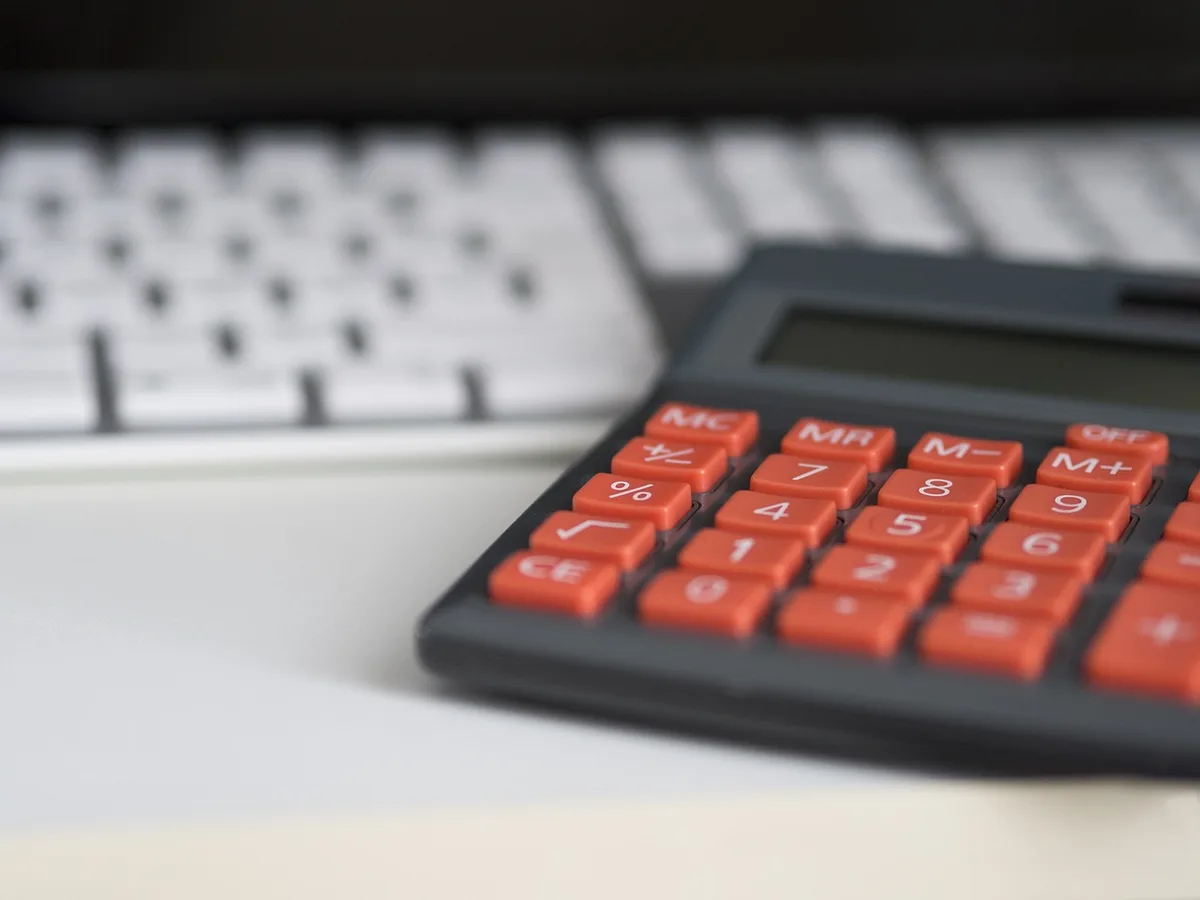 Maquette de maison et calculatrice sur un bureau pour illustrer le gain de taux