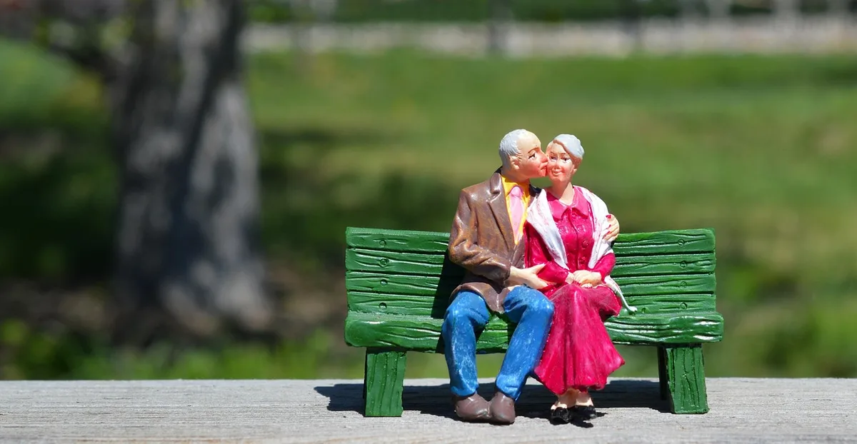 Documents de mariage et acte de décès posés sur une table avec mains anonymes